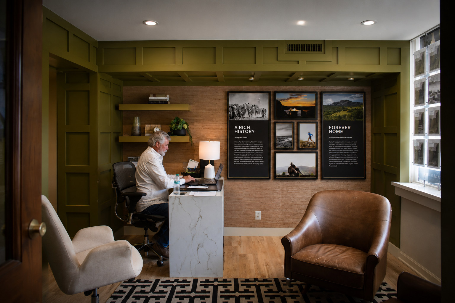 Jeff Davis working at his desk inside the Stringfield Sales Center, with the community's history displayed on the wall behind him